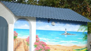 A building with a mural of a beach scene, a lighthouse, and a boat. - House / Villa - FouesnantHouse with garden (Fouesnant)