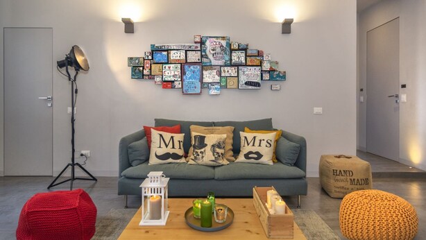 Een woonkamer met een bank, een salontafel, een lamp en een wanddecoratie.