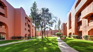 Une cour intérieure avec un chemin central, entourée de bâtiments dotés de balcons et de fenêtres.