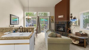 A modern kitchen with a large island, a dining area with outdoor seating, and a fireplace.