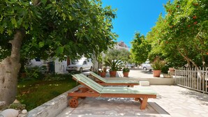 A patio with two wooden lounge chairs, a stone floor, and potted plants. - DOROTEA 1, 3-room apartment for 6 persons, 50m from the pebble beach (Okrug Gornji)