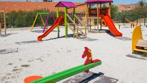A playground with slides, swings, and a climbing structure. - DOROTEA 1, 3-room apartment for 6 persons, 50m from the pebble beach (Okrug Gornji)