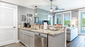 A modern kitchen with a dishwasher, a coffee maker, and a large island.
