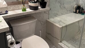 Een badkamer met toilet, bidet en douche.