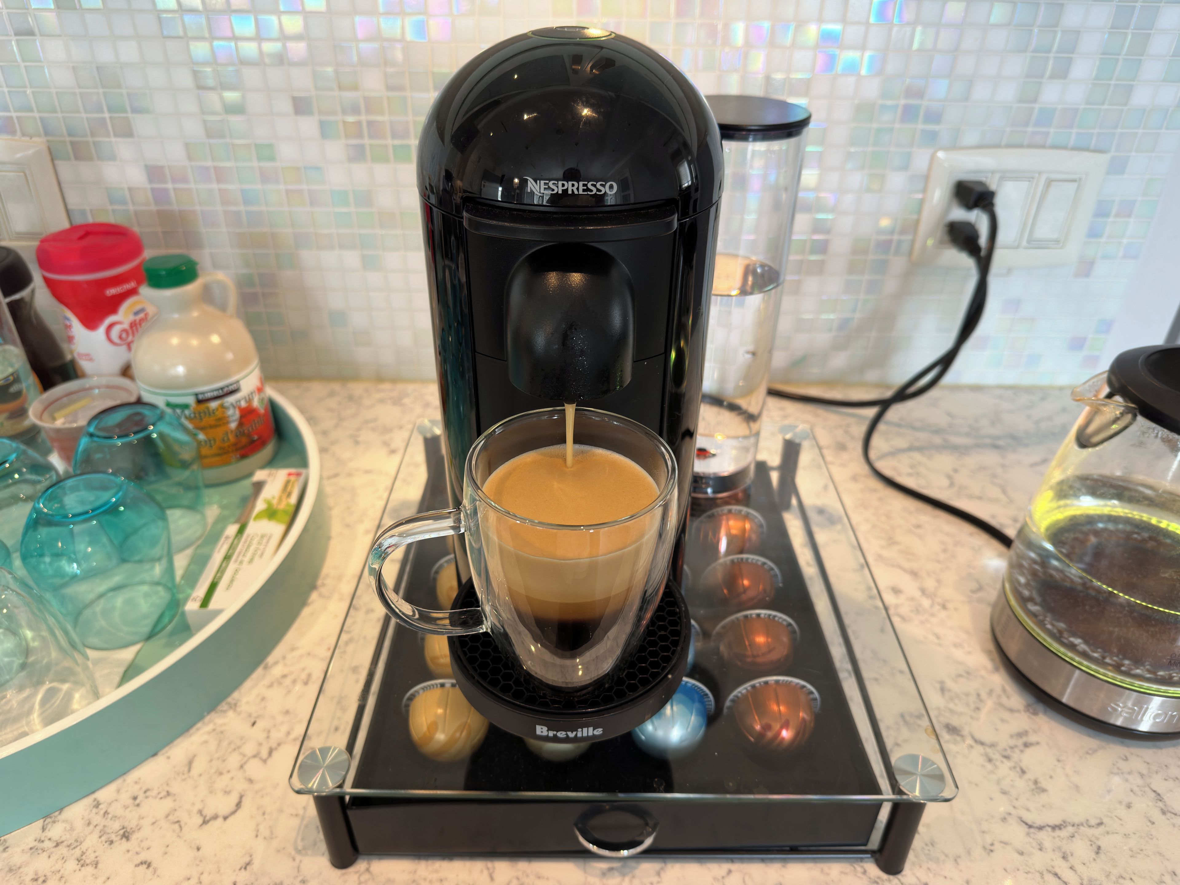 Una cafetera Breville con una taza de café sobre la encimera.