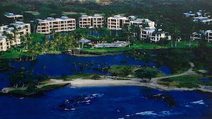 Ein Resort mit mehreren Gebäuden, einem zentralen Pool und umgebender Bepflanzung.