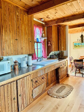 Une cuisine en bois avec un plan de travail en bois, un évier et une machine à café.