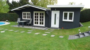 A modern house with a pool, a patio with a table and chairs, and a well-maintained lawn. - Vacation apartment Meyer with private pool and garden sauna, exclusive FEWO. (Mähren)