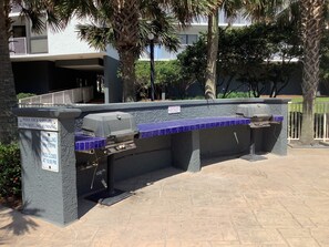 Enjoy al fresco dining with a grill and seating in a serene landscaped setting.