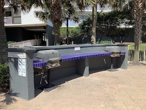 Enjoy al fresco dining with a grill and seating in a serene landscaped setting.