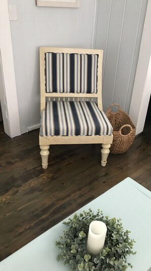 Relax in a vintage chair with a striped cushion, set against a light-colored backdrop.