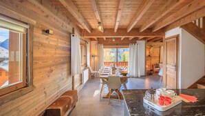 A wooden interior with a dining area, a bench, and a kitchen counter. - Modern chalet 10pers - close to slopes and center (Châtel)
