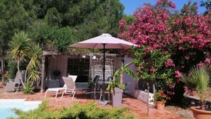 A patio with a pool, a barbecue area, and a pergola with a white umbrella. - Former sheepfold with swimming pool, among the pines, near the sea. (Aude)