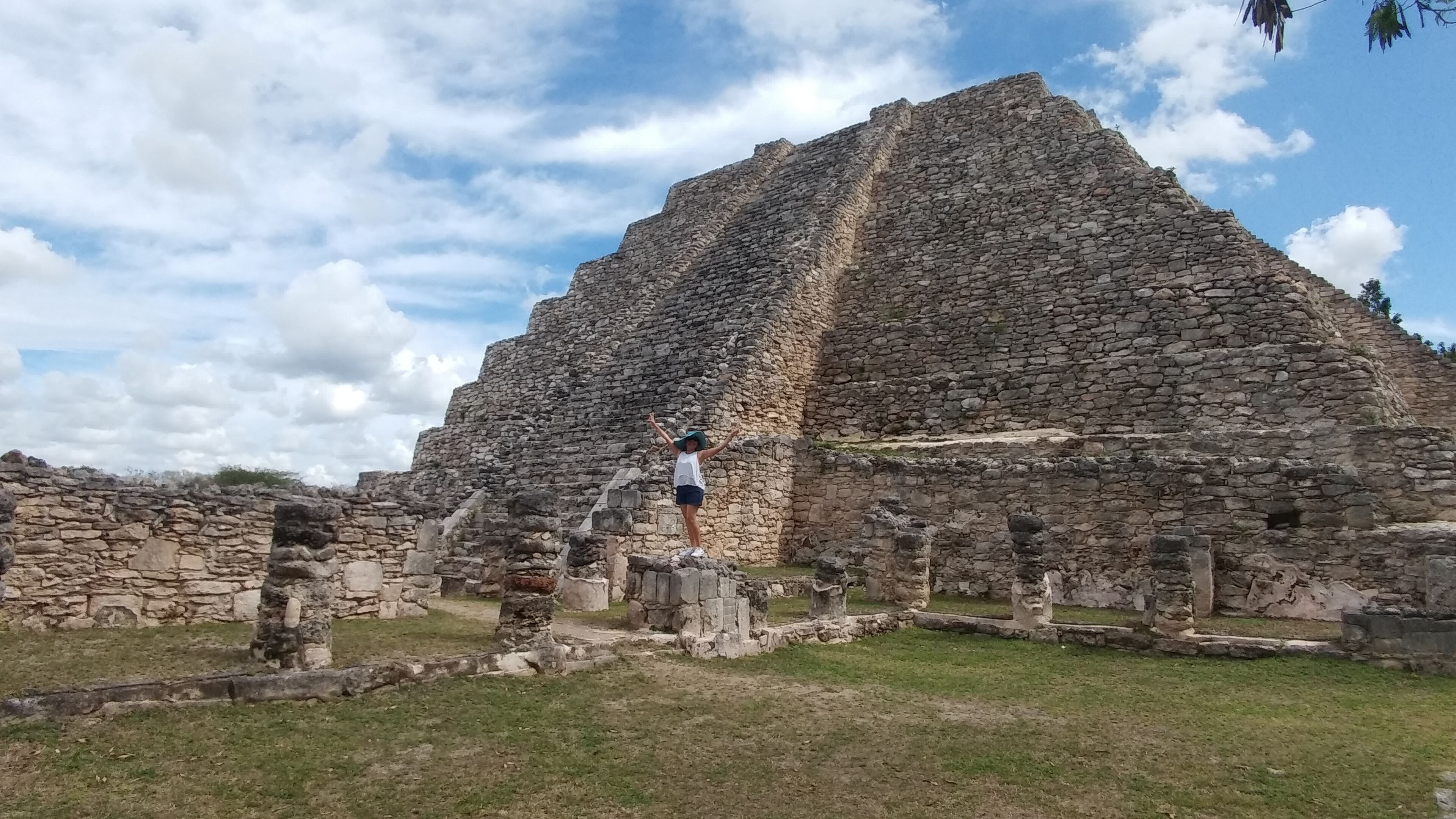 Una estructura piramidal de piedra antigua con ruinas a su alrededor.