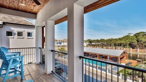 A balcony with a view of a swimming pool and a forested area.