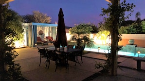 Ein Außenbereich mit Pool, Sitzgelegenheiten und überdachtem Bereich.