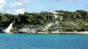 Una propiedad costera con una casa en una colina con vistas al mar.