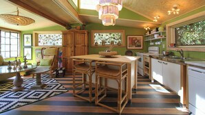 A kitchen with a dining table, chairs, and a hanging light fixture.