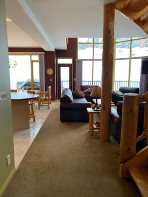 A cozy living room with a sofa, a coffee table, and a dining area with a table and chairs.