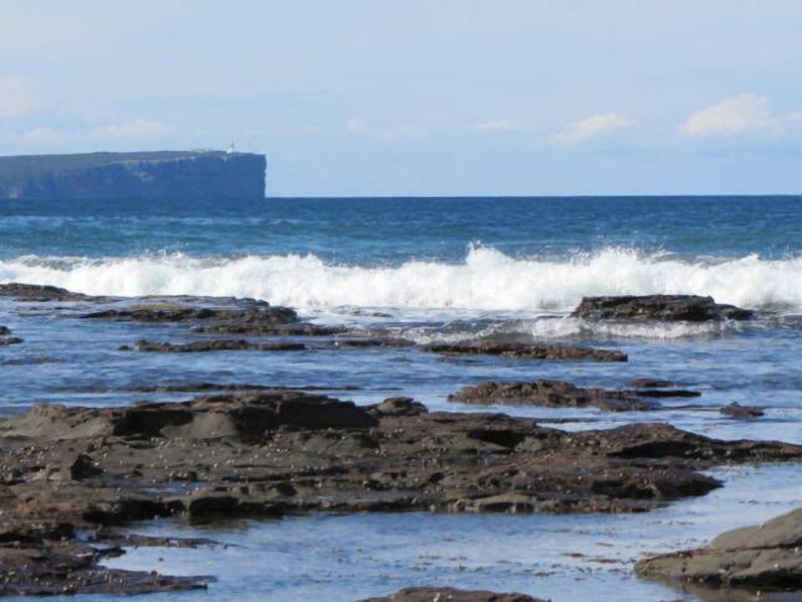 A rocky shoreline with waves crashing onto the rocks.
