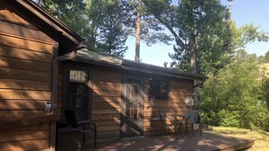 Une cabane en bois avec une véranda, une porte et une fenêtre.