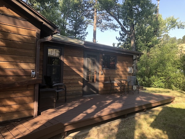 Eine Holzhütte mit Veranda, Tür und Fenster.
