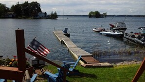 A lakeside dock with boats, a wooden pier, and a flag.