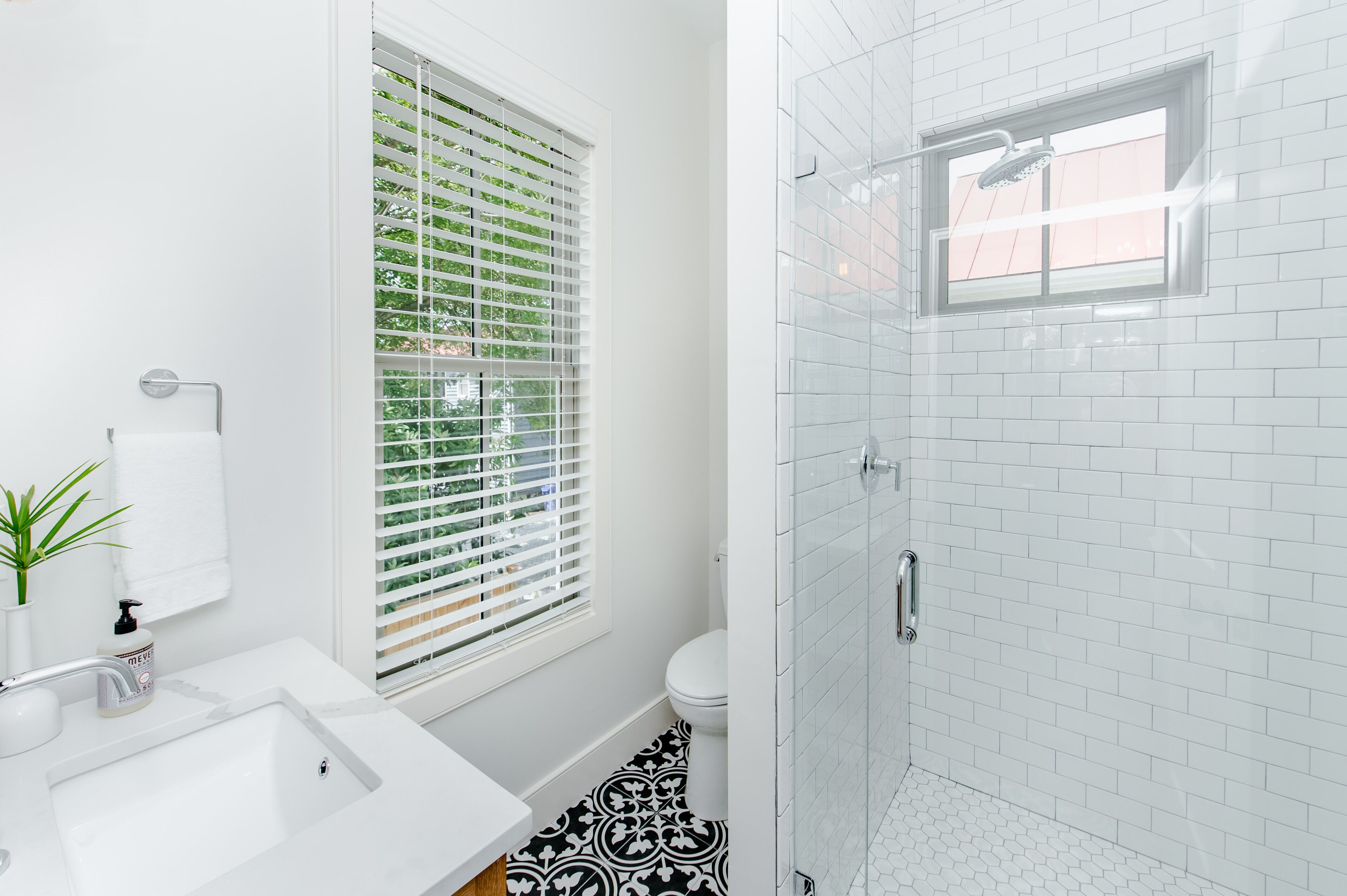 A modern bathroom with a white sink, toilet, and shower.