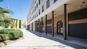 Un edificio a più piani con una passerella coperta, ampie finestre e un basculante chiuso.