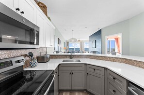 A modern kitchen with a microwave, stove, and sink.