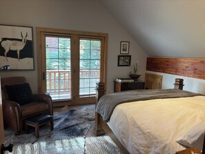 A bedroom with a bed, a chair, a desk, and a window with blinds. - 4 Bedroom Luxury Ski in/ Ski Out Powder Ridge Cabin W/ Hot Tub (Big Sky)