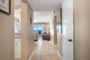 Guest rooms lead from this well-maintained corridor with framed artwork and a ceiling fan.