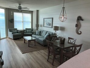 A living room with a sofa, coffee table, and dining table with chairs.