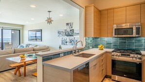 A modern kitchen with a central island, stainless steel appliances, and a view to the outside. - Seahorse Retreat - Double The Fun, BEACHFRONT, In Carpinteria! (Carpinteria)