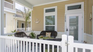 A porch with wicker furniture, a potted plant, and a door with the number 14909. - Read Our Reviews Gorgeous 2 BR Poolside T/h, 3 minute walk to beach! (Corpus Christi)