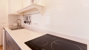 A modern kitchen with a built-in stovetop, a sink, and a small refrigerator. - Princesa Ico 1 bedroom apts. (Puerto del Carmen)