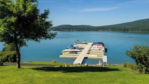A dock with boats and a grassy area with trees.