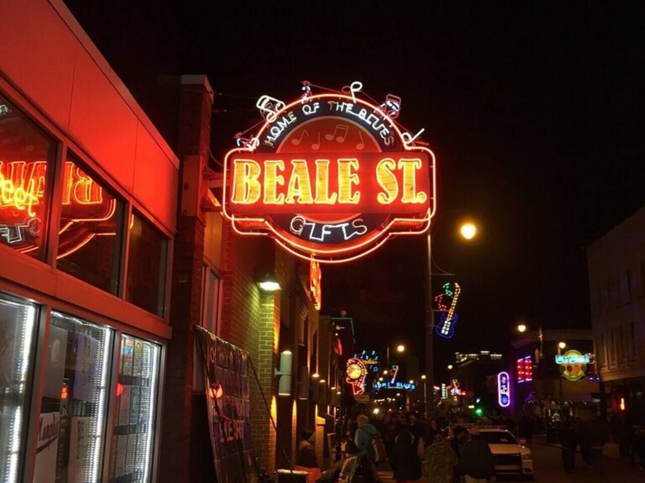 A neon sign for Beale St. Gifts with a circular design and musical notes.