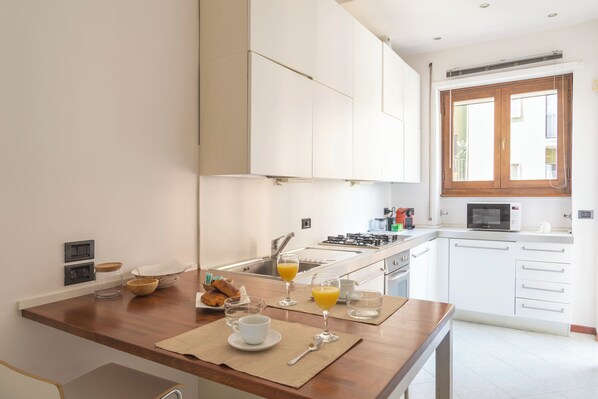 Enjoy cooking in this well-equipped kitchen with a gas stove, microwave, and stainless steel sink.