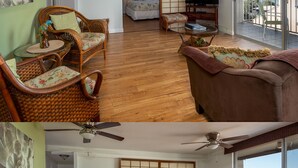 A room with a large window, a ceiling fan, a television, and a traditional Japanese sliding door.