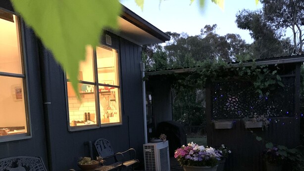 A wooden deck with outdoor furniture, a covered patio area, and potted plants. - Pyrenees Farm Stay Amphitheatre. (Pet friendly) Bed and Breakfast. (Amphitheatre)