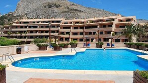 A hotel with a swimming pool, multiple balconies, and a mountain in the background. - Costa Blanca, Altea, beautiful apartment with fantastic panoramic views (Altea)