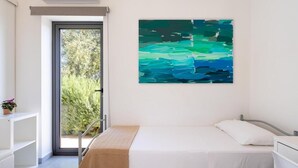 Une chambre à coucher avec un lit, une fenêtre, une porte et un tableau accroché au mur.