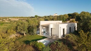 Une maison moderne dotée d’un patio, d’une piscine et offrant une vue sur le paysage environnant.