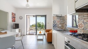Une cuisine moderne équipée d’une cuisinière à gaz, d’un évier et d’un coin repas avec une table et des chaises.