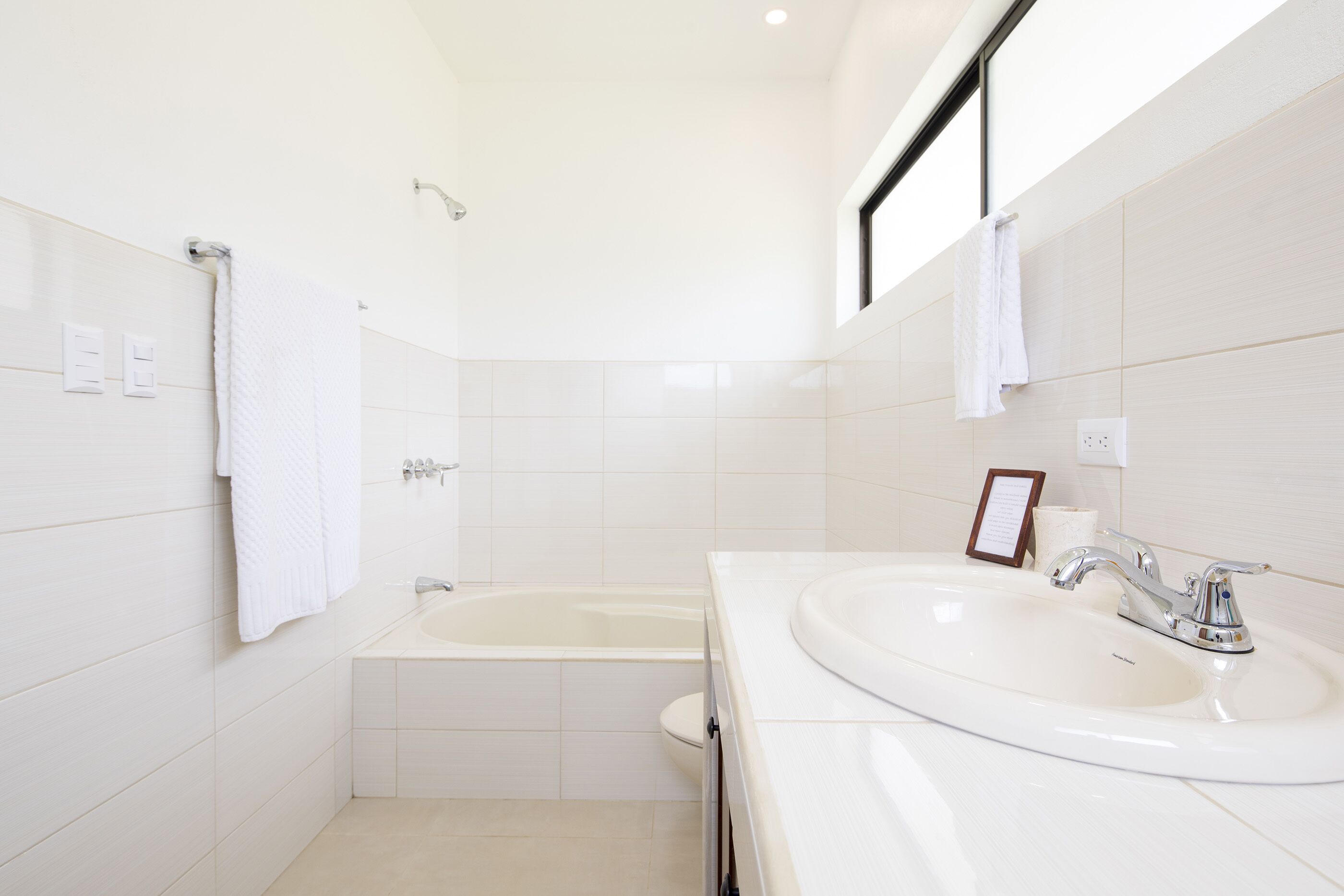 Un bagno moderno con una vasca, un lavandino e uno specchio.