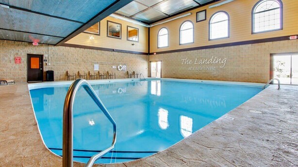 Una piscina interior con vista clara al techo, paredes y ventanas.