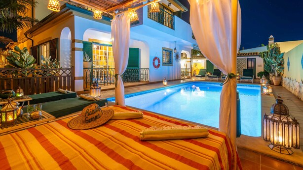 A poolside area with a bed, lounge chairs, and a pool. - Riad Serpa Galé - Luxury, private pool, AC, wifi and 5 mins from the beach (Albufeira)