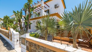 A white building with a stone wall, palm trees, and a tiled patio. - Riad Serpa Galé - Luxury, private pool, AC, wifi and 5 mins from the beach (Albufeira)