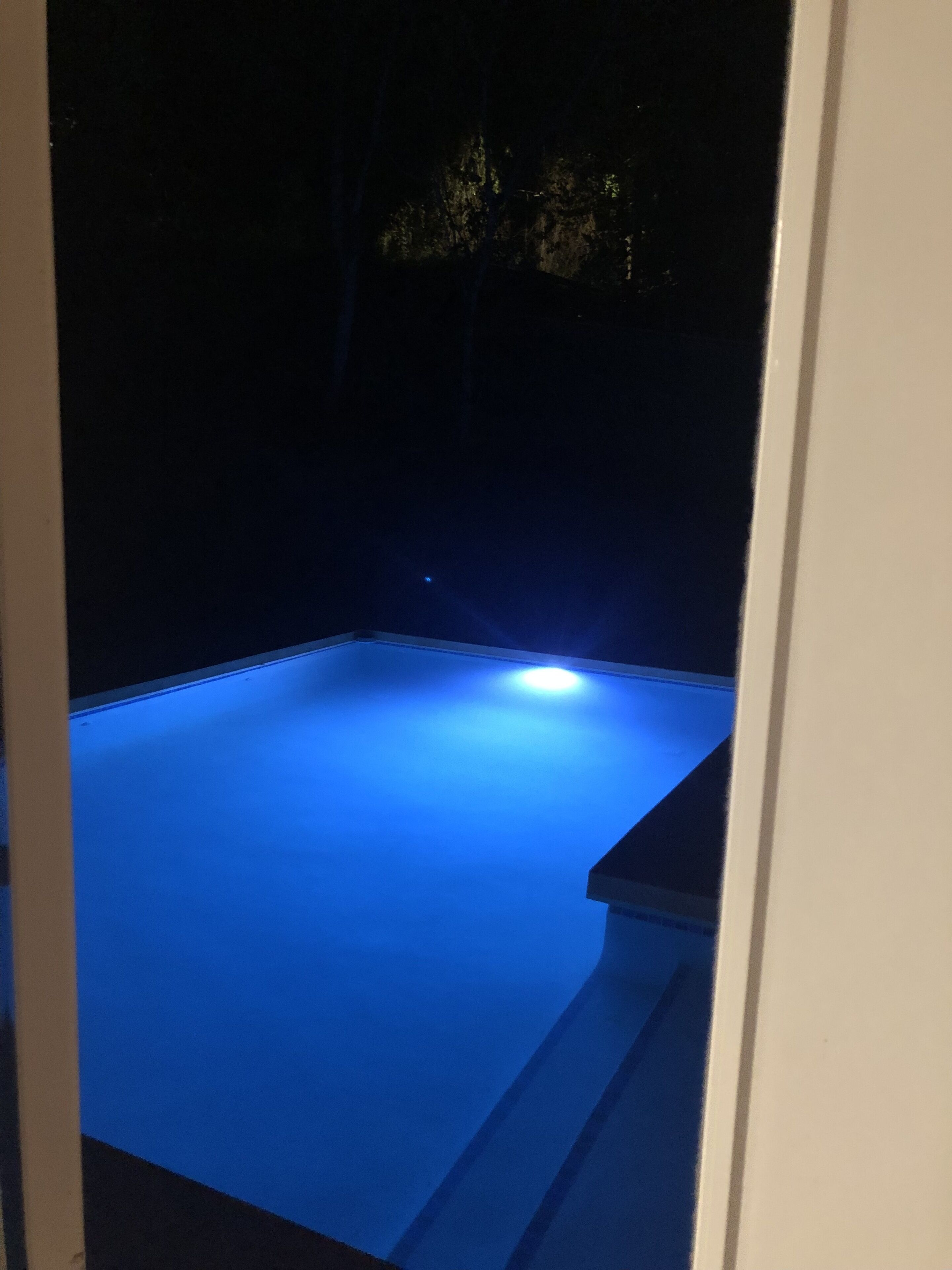 Piscina com tons de azul, rodeada por uma paisagem rochosa escura.